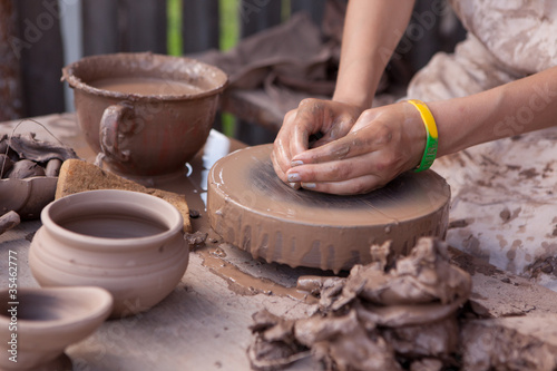 A potter shapes a piece of pottery