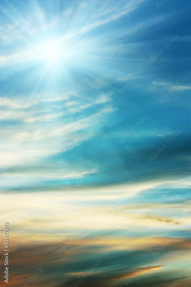 Sky blue background with wispy clouds and a shining sun