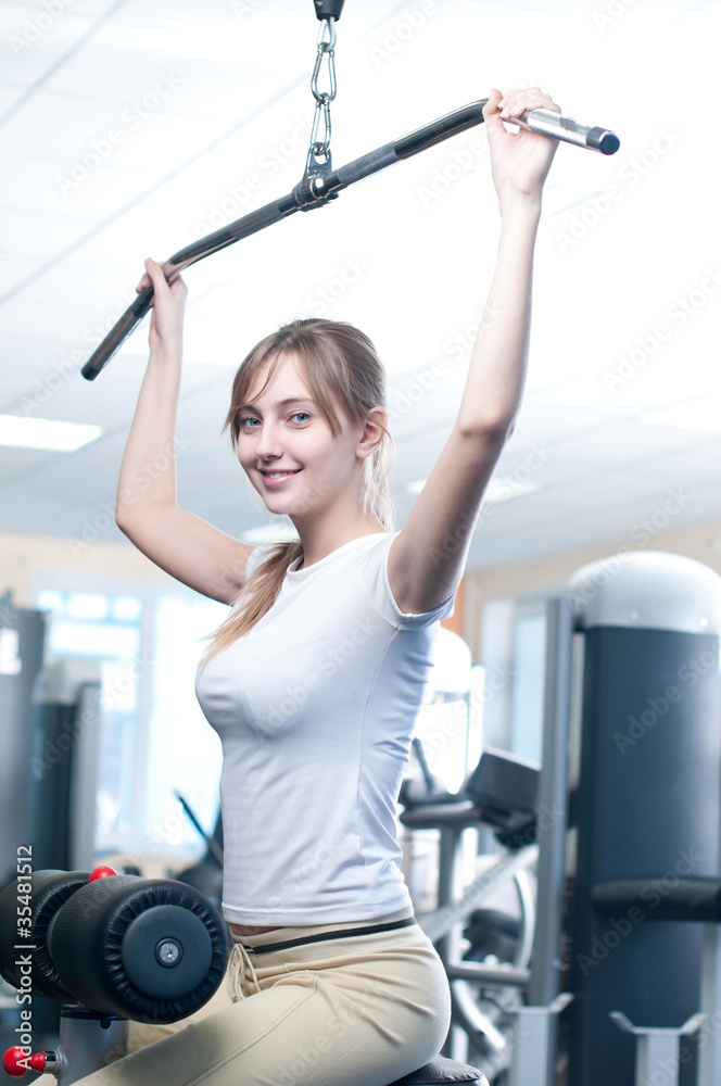 Powerful casual woman lifting weights in gym Powerful casual woman lifting weights in gym