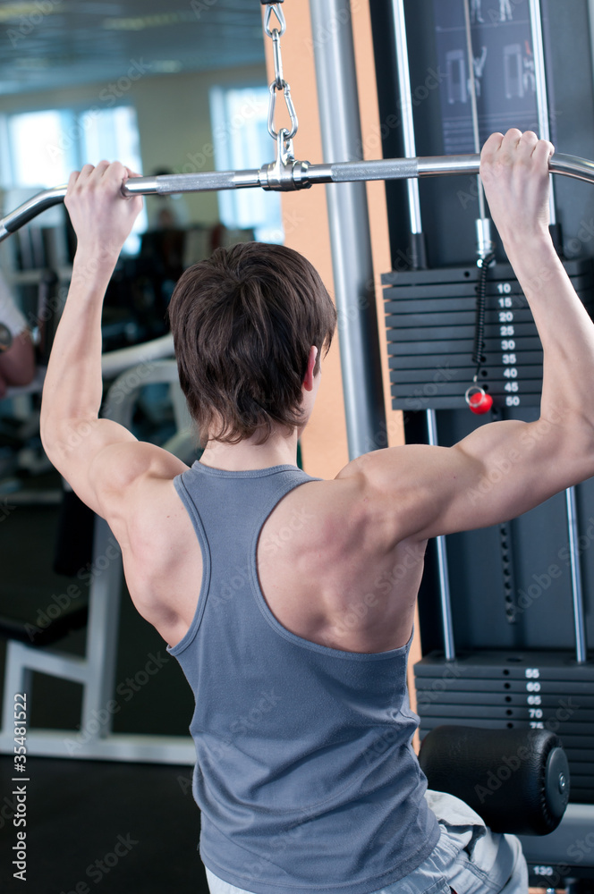 Naklejka premium Powerful muscular man lifting weights in gym