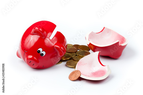 Broken piggy bank or money box with coins isolated on white