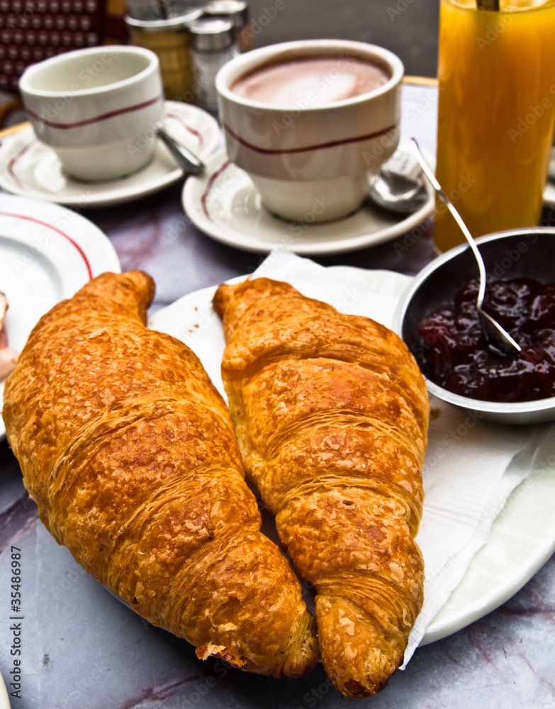 Breakfast with coffee and croissants in a basket on table Breakfast with coffee and croissants in a basket on table