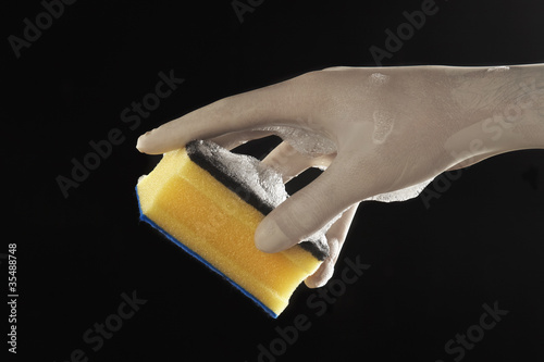 mano con guante de latex con esponja con espuma en fondo aislado photo