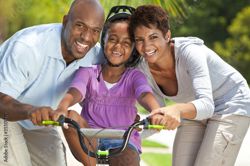 African American Family WIth Girl Riding Bike & Happy Parents photo