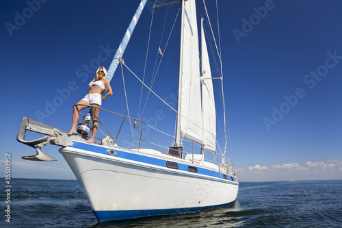Beautiful Young Blond Woman on the Bow of a Sail Boat