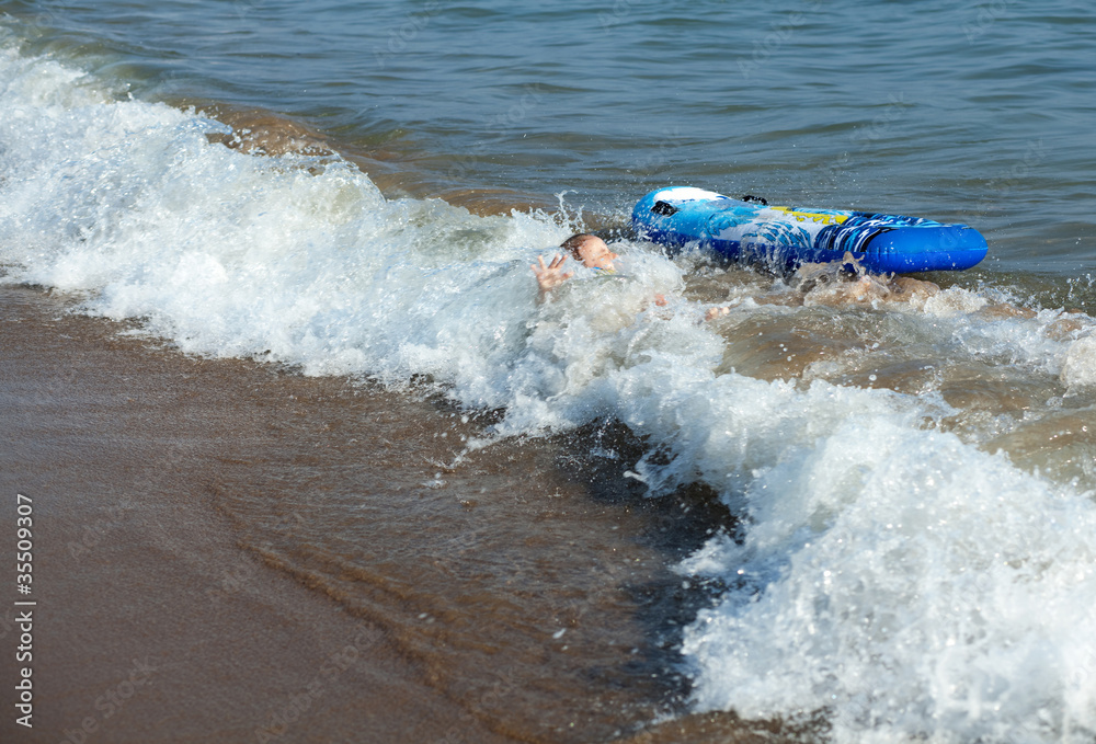 Naklejka premium Sea wave covered the child.