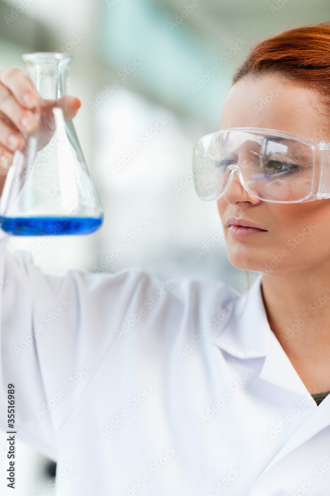 Portait of a science student looking at an Erlenmeyr flask Portait of a science student looking at an Erlenmeyr flask