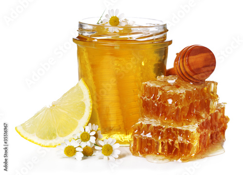 Fresh honey, chamomile and lemon on white isolated background