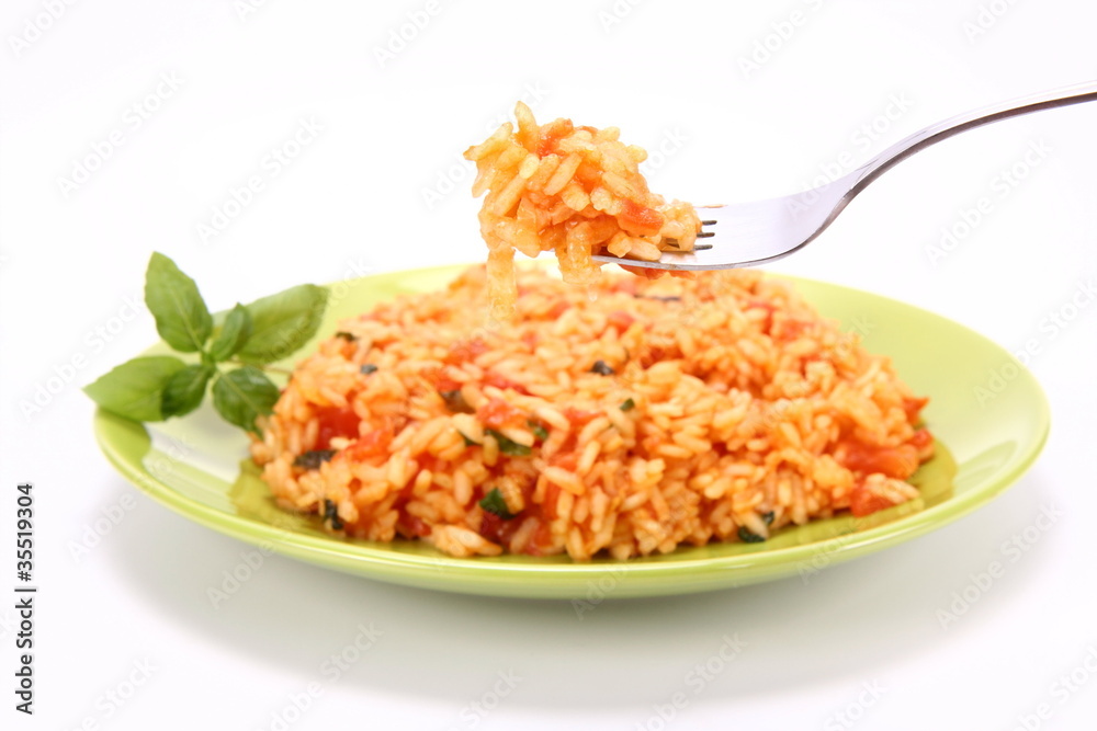 Risotto with tomatoes being eaten with a fork Risotto with tomatoes being eaten with a fork