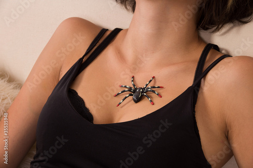 Artificial spider sitiing on girl's chest