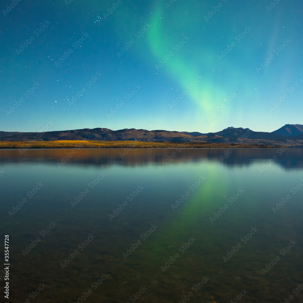 Northern lights and fall colors at calm lake