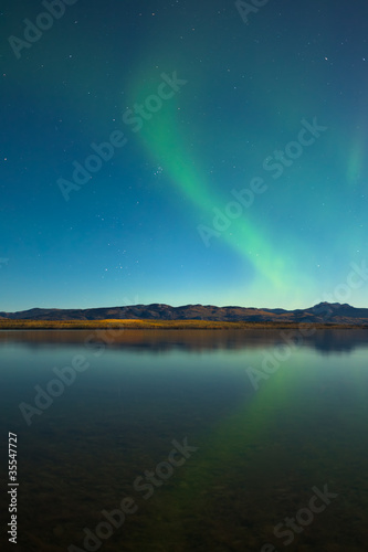 Northern lights and fall colors at calm lake © PiLensPhoto