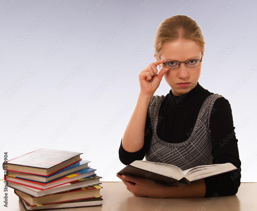 Strict woman with a book sitting at table Strict woman with a book sitting at table