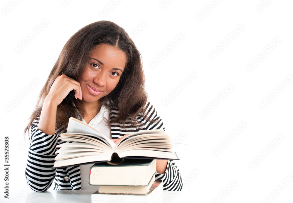 Smiling student with open books doing homework at desk Smiling student with open books doing homework at desk