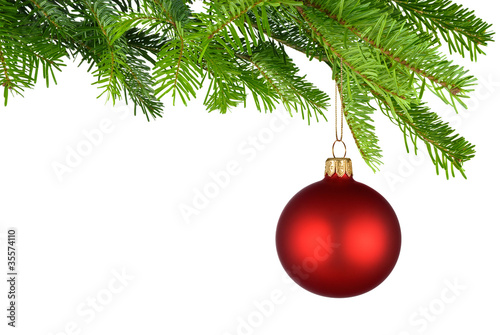 Rot leuchtende Christbaumkugel hängt am frischen Zweig