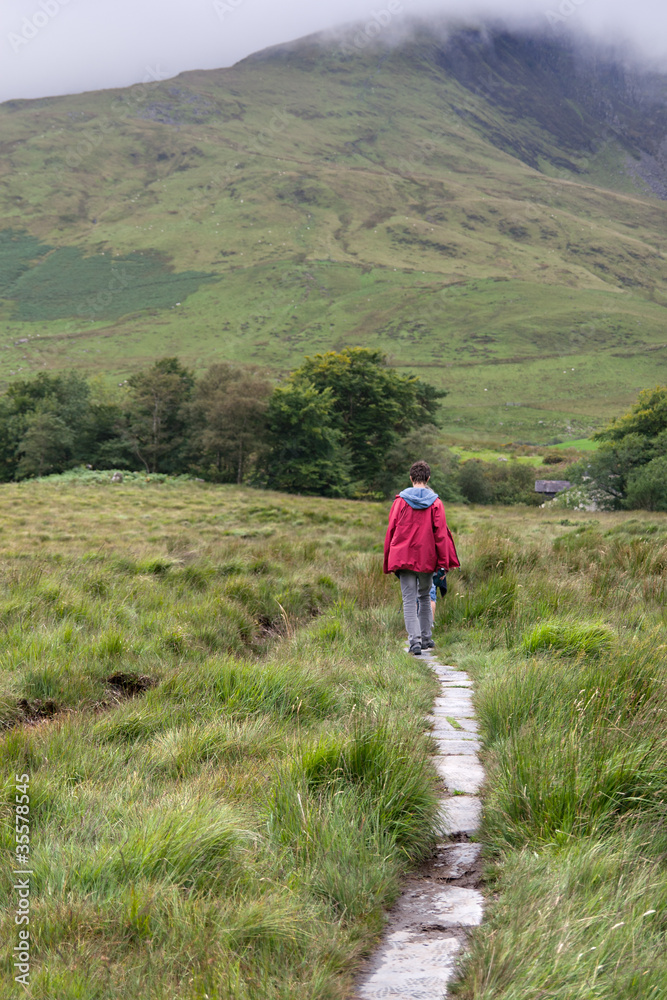 Male trekker walks along a mountain path in Snowdonia