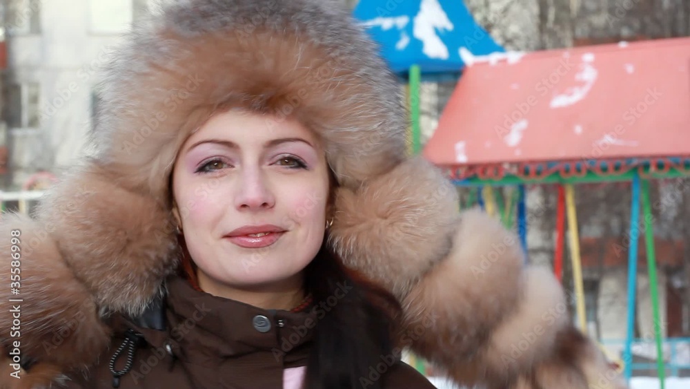 Woman looks and smiling against background of playground Woman looks and smiling against background of playground