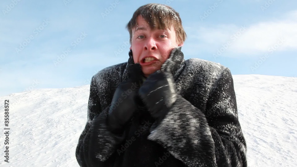 The man all in snow is shivering, seems that he was cold