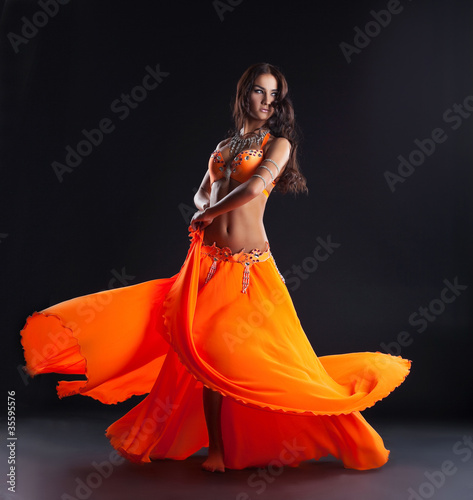 beauty dancer posing in traditional orange costume