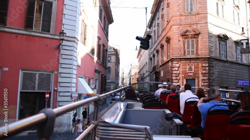 tourists riding on bus roof through city center photo