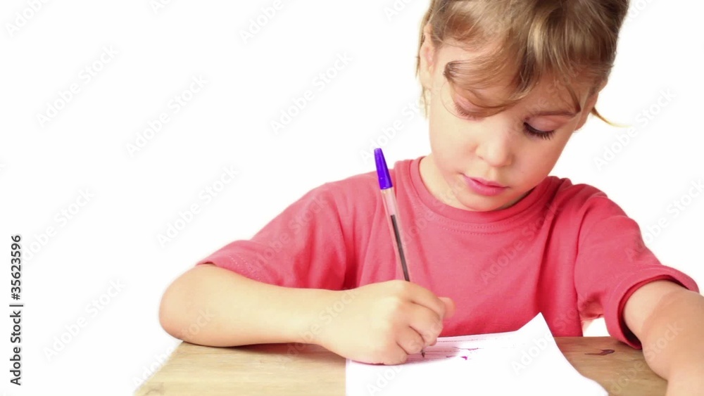 Girl doing homework, she writes pen on paper on table Girl doing homework, she writes pen on paper on table