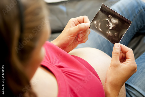schwangere frau betrachtet ultraschallbild photo