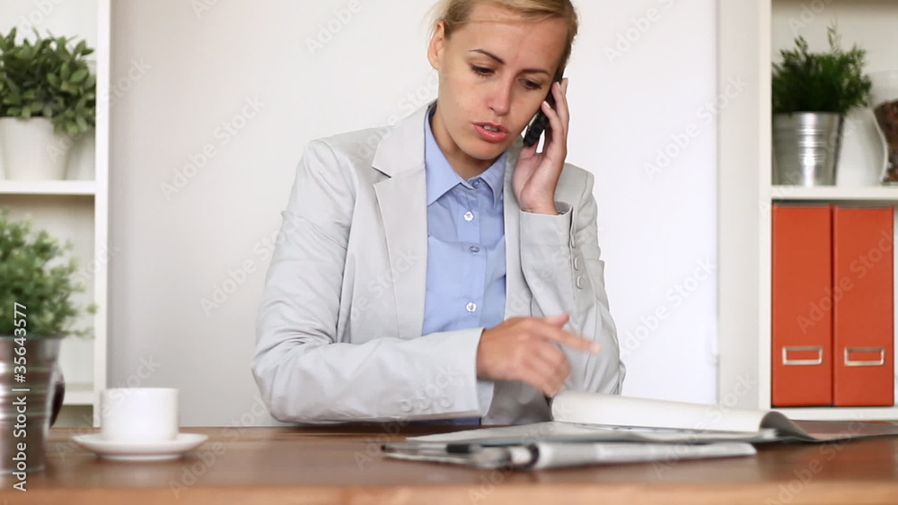 Angry businesswoman with documents screaming to cell phone Angry businesswoman with documents screaming to cell phone