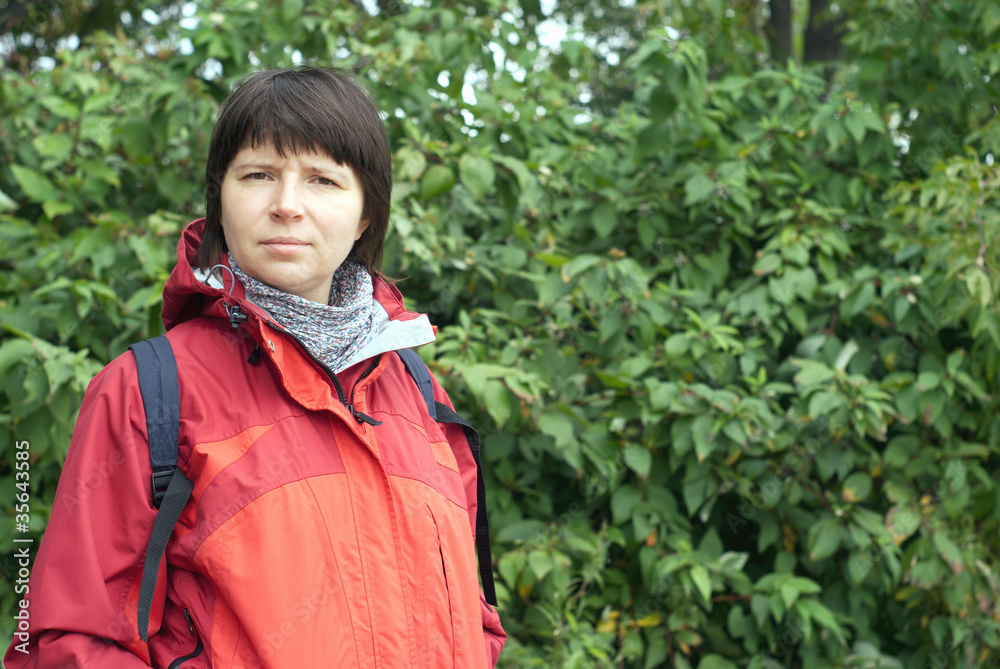 Portrait of woman dressed in red blazer with backpack on nature Portrait of woman dressed in red blazer with backpack on nature