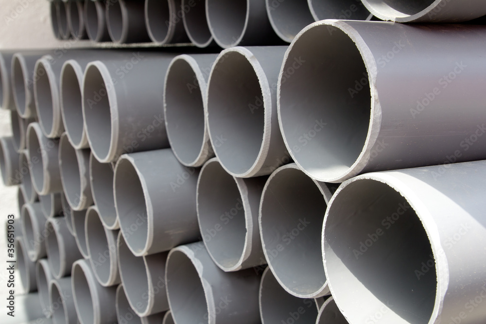 gray PVC tubes plastic pipes stacked in rows gray PVC tubes plastic pipes stacked in rows