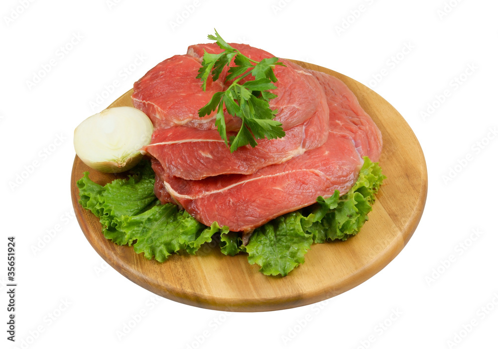 Raw beef meat with fresh vegetables on wooden cutting board