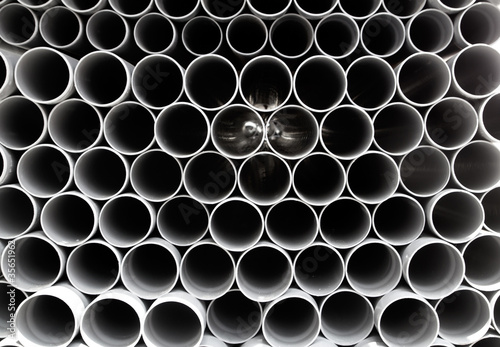 gray PVC tubes plastic pipes stacked in rows
