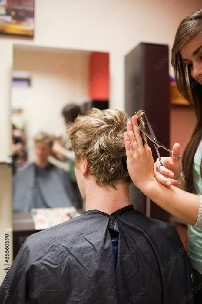 Fototapeta premium Portrait of a blond-haired man having a haircut