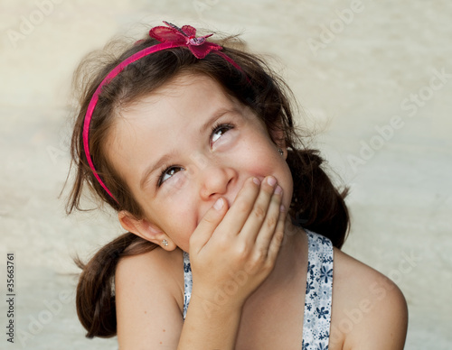 Smiling girl closing her mouth with her hand photo