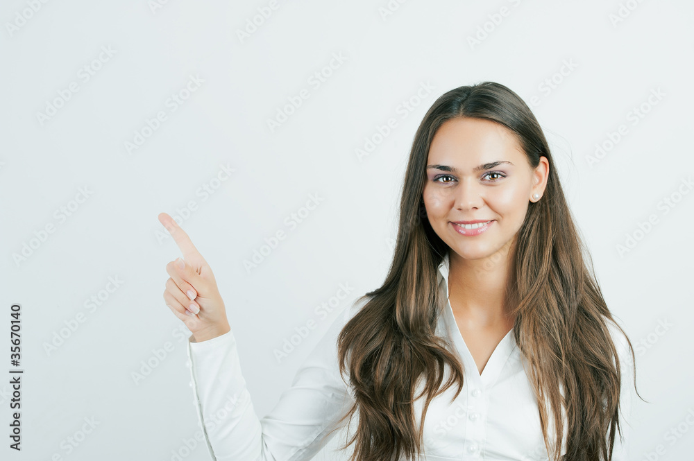 Happy smiling young business woman showing blank area for sign o Happy smiling young business woman showing blank area for sign o