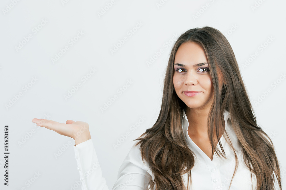 Happy smiling young business woman showing blank area for sign o Happy smiling young business woman showing blank area for sign o