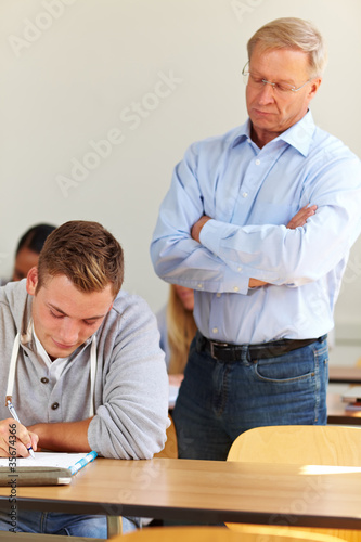 Lehrer kontrolliert bei Prüfung
