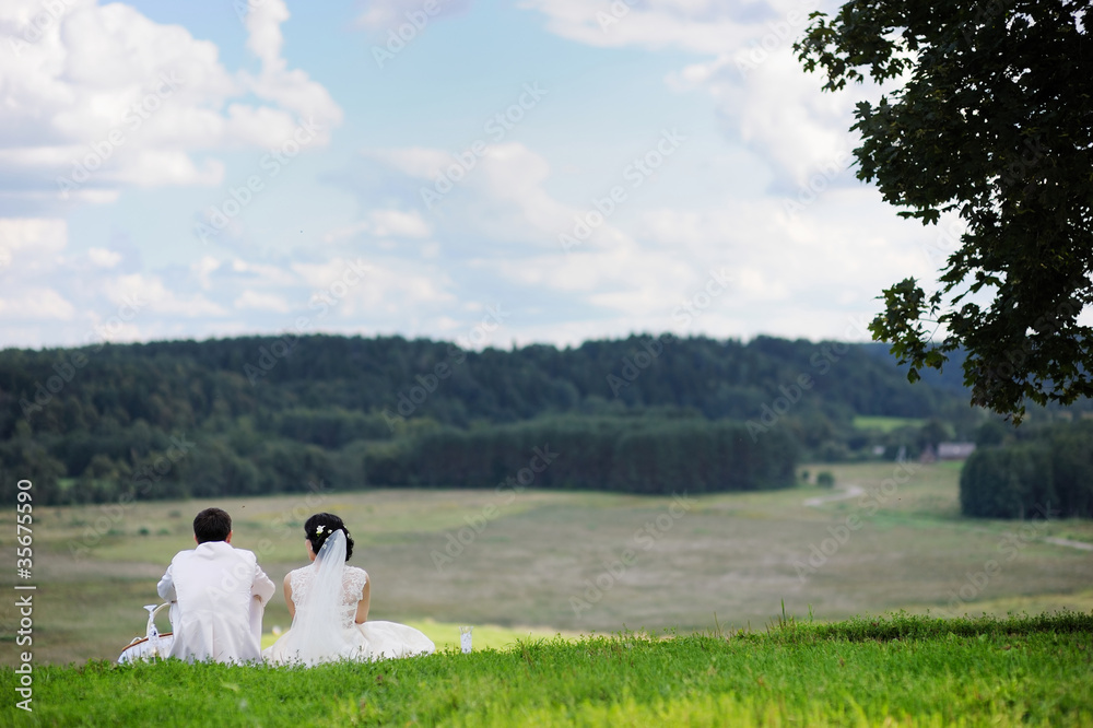 Bride and groom resting together outdoors Bride and groom resting together outdoors