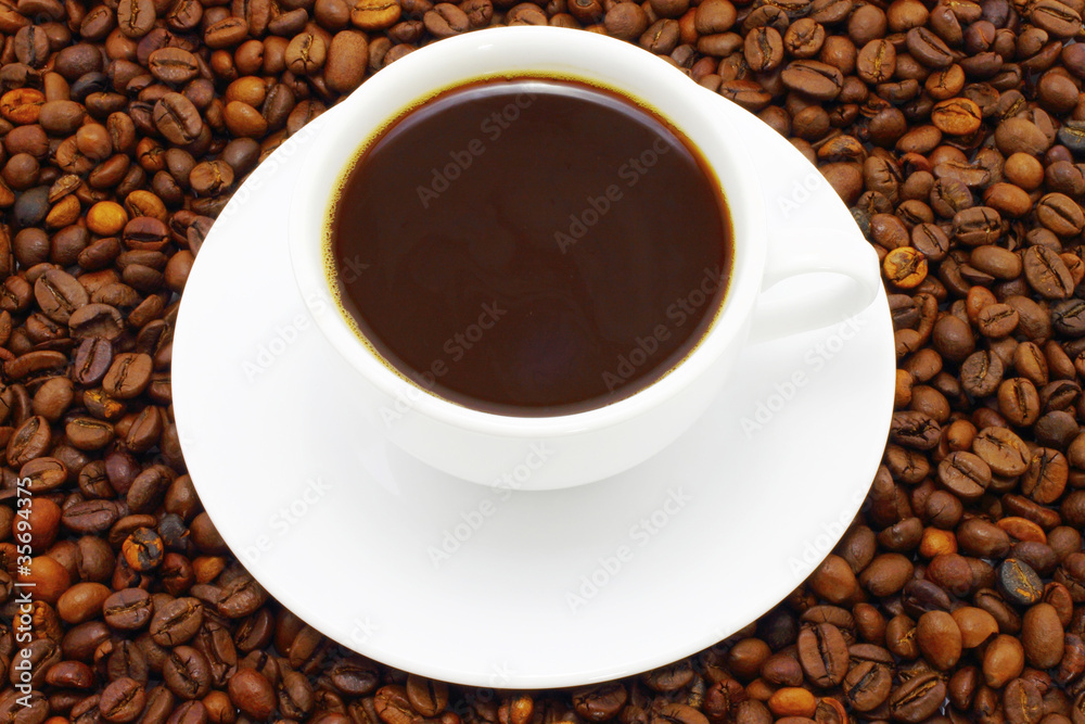 Fototapeta premium Cup of coffee on a coffee beans background
