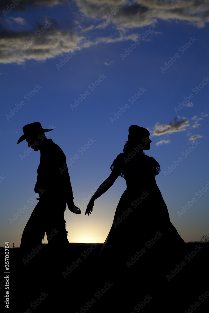 Cowboy couple silhouette walking away