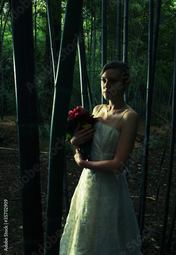 Beautiful young woman in bamboo forest, cross processed