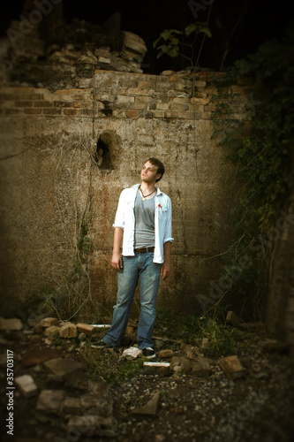 Man standing by an old wall