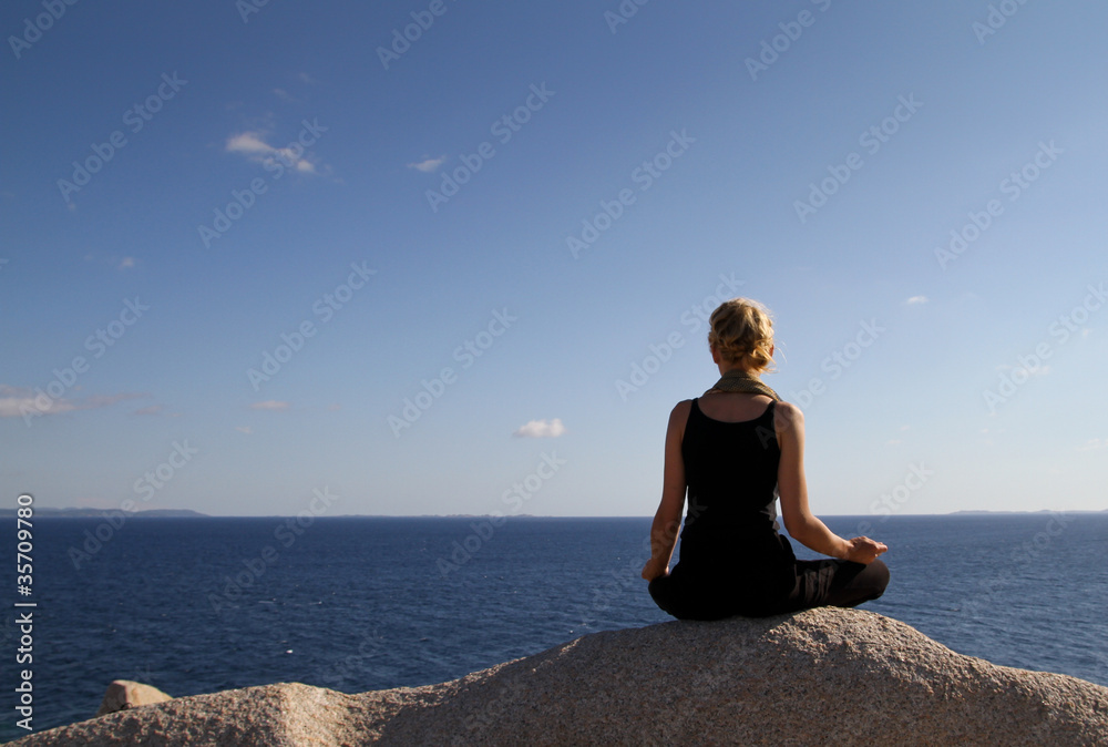 girl sitting on rock over ocean