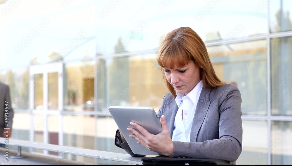 Business people working outside on electronic tablet Business people working outside on electronic tablet