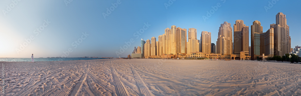 Naklejka premium Kobieta patrzy na Dubai City (Marina) na plaży Jumeirah