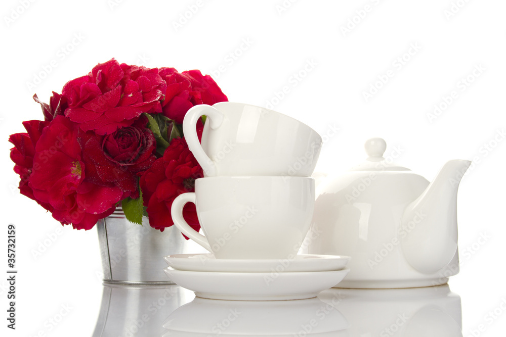 White crockery for tea and a bouquet of roses