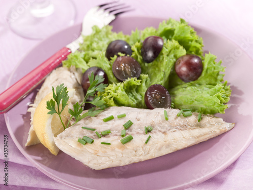 mackerel fillet with salad and slice grapes over lilac table