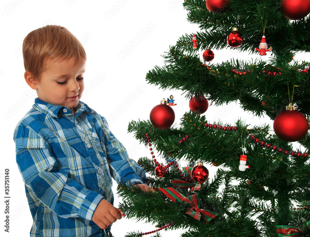 Kleiner Junge schmückt den Weihnachtsbaum