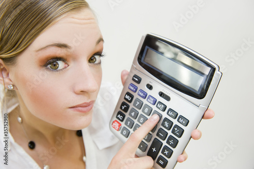 Jeune femme avec une calculatrice photo
