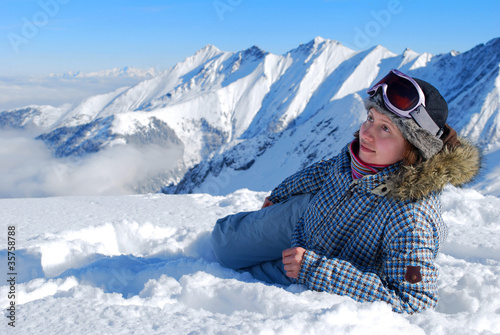 Young female skier lying in snow