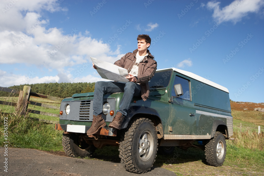 Fototapeta premium Young man in countryside with SUV